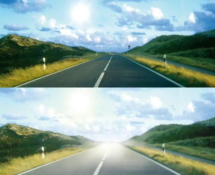 Straße verläuft zwischen grünen Wiesen auf beiden Seiten in ländlicher Landschaft